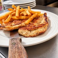 Two grilled chicken breasts with seasoned fries