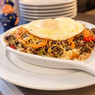 Mexican Skillet: seasoned ground beef, peppers, onion and melted cheese with chipotle sauce, topped with a fried egg over hash browns
